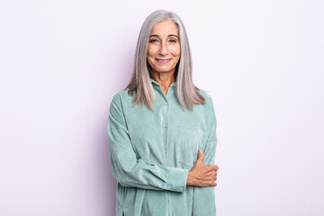 middle age gray hair woman laughing shyly and cheerfully, with a friendly and positive but insecure...