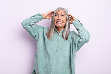 middle age gray hair woman feeling stressed, worried, anxious or scared, with hands on head,...