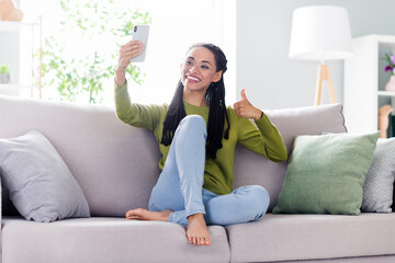 Obraz premium Photo of sweet shiny lady wear green pullover sitting couch showing thumb up taking selfie modern gadget indoors room home house