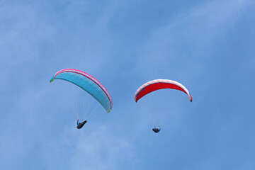 	
Paragliders in a blue sky	