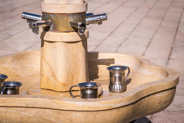 Fountain with faucets and silver washing cup, jugs, for the purification or ablution ritual...