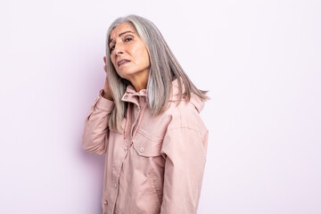 middle age gray hair woman looking serious and curious, listening, trying to hear a secret...