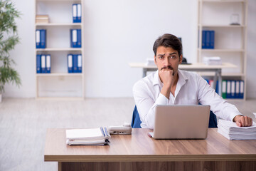 Young male employee and too much work in the office