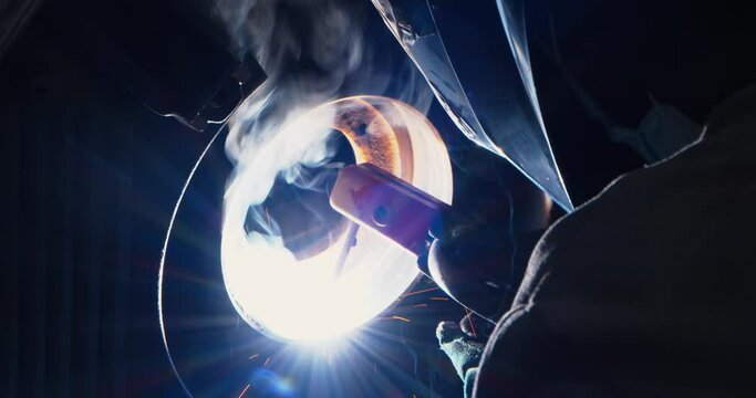 Ring light with sparks produced by a welder working on an engine, close up