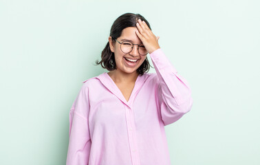 pretty teenager woman laughing and slapping forehead like saying d’oh! I forgot or that was a...