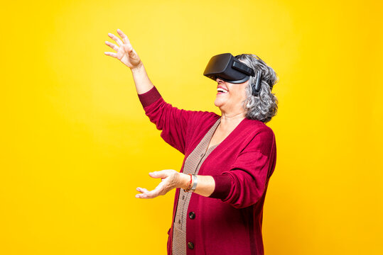 Woman gesturing while wearing virtual reality headset against yellow background