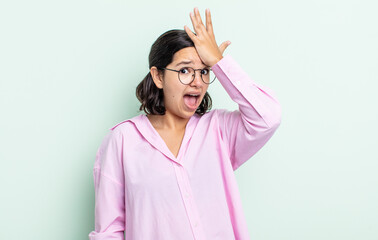 pretty teenager woman raising palm to forehead thinking oops, after making a stupid mistake or...