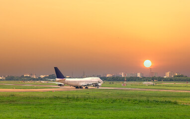 Fototapeta na wymiar Cargo plane landing at Tan Son Nhat International Airport with sunset sky background, Ho Chi Minh City, Vietnam