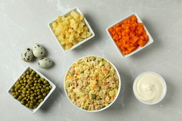 Olivier salad and ingredients on light background
