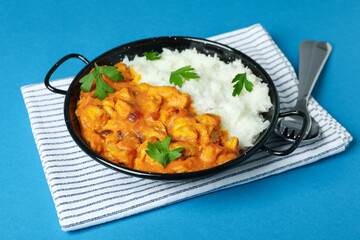 Concept of tasty food with chicken tikka on blue background