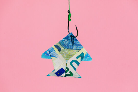 Fish shaped banknote hanging on hook