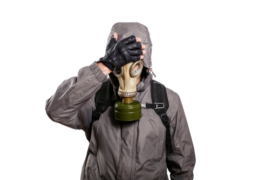 An isolated shot of a man dressed in a gas mask, a jacket with a hood, a backpack, put his hand on his head from grief and trouble. On a white isolated background