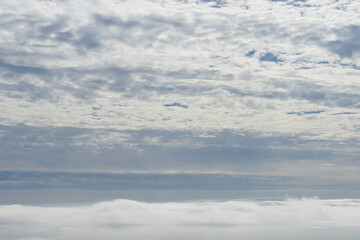 fluffy clouds and fog over the Mediterranean sea atmospheric cloudscape and overcast sky in Spain