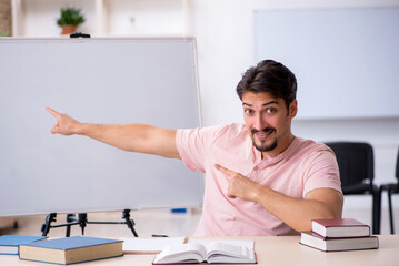 Young male teacher in the classroom during pandemic