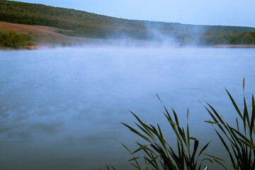 Natural view of a calm lake on a foggy morning