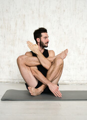 Fototapeta na wymiar A young man is doing yoga. Yoga coach on a light background.