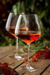 Autumn cozy romantic evening outdoors, wooden table with glasses with rose wine and grapes