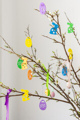 Blooming cherry branches decorated with colorful ribbons with Easter eggs, decorative rabbits, happy Easter, holiday decoration
