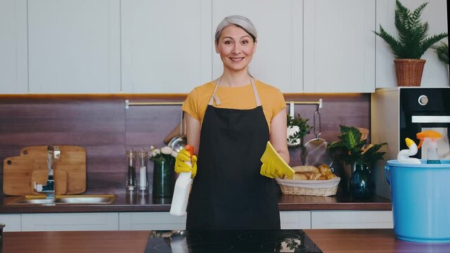 a mature woman is unhappy with an ineffective cleaning agent in the kitchen