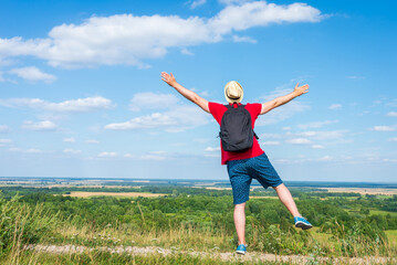 Young man admiring beautiful view of the forest landscape rear view.Young man standing alone summer day outdoors.