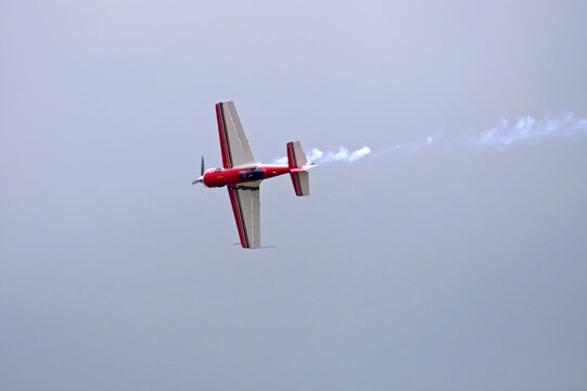 Acrobatic manoeuvres. Light sport plane flying in the sky.