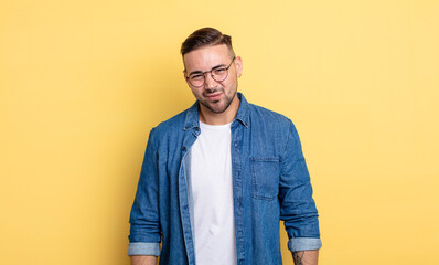 young handsome man looking happy and friendly, smiling and winking an eye at you with a positive...