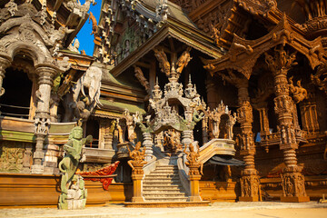 Fototapeta na wymiar Wooden Temple in Pattaya. Traveling in Thailand. Wooden sculptures of beautiful carved patterns on the roof.