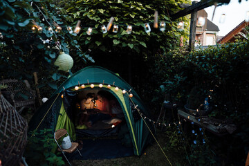 Senior woman with girl using digital tablet while camping at backyard