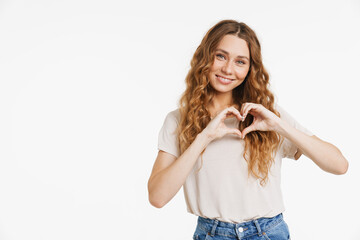 Young ginger woman in t-shirt smiling and showing heart gesture