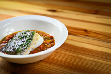 Delicious dish of fresh hake with fresh peppers and vegetables. Typical hemp plate of the cantabrian. Gourmet dish of fresh fish and vegetables.