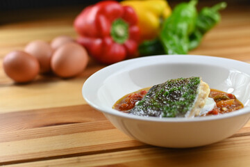 Delicious dish of fresh hake with fresh peppers and vegetables. Typical hemp plate of the cantabrian. Gourmet dish of fresh fish and vegetables.