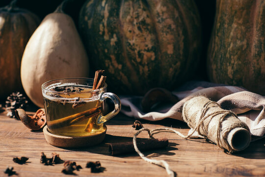 Pumpkins and glass of hot tea with cinnamon and star anise