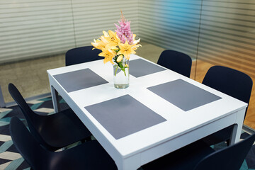 a bouquet of flowers on the kitchen table. cozy minimalist interior for breakfast. modern kitchen design in the office