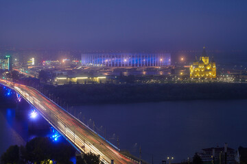 Nizhny Novgorod, Russia - September 22, 2021. View of the new stadium and the Alexander Nevsky Cathedral. Twilight . Fog over the river - 465247309