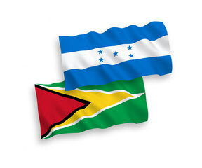 National vector fabric wave flags of Co-operative Republic of Guyana and Honduras isolated on white background. 1 to 2 proportion.