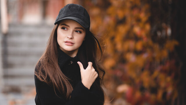 Autumn portrait of an attractive girl in a baseball cap. Autumn shades. Stylish girl