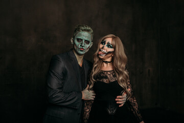 The image of a skeleton girl and the image of a Frankenstein man on Halloween in the dark. an image for a couple on Halloween. fooling around, showing their tongue