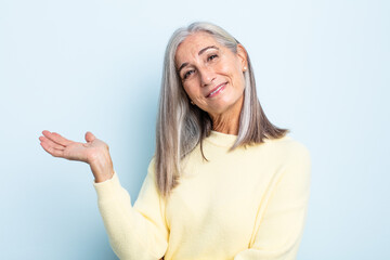 middle age gray hair woman smiling cheerfully, feeling happy and showing a concept in copy space with palm of hand - obrazy, fototapety, plakaty