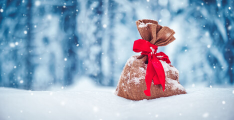 Present bag lying on the fresh snow in winter in forest