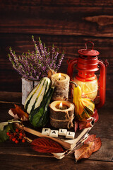 Autumn still life with ornamental gourds and oil lamp in rustic style