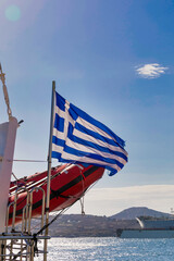 Greek Flag. Isolated. Sky in the background. Blue and white flag blowing in the wind next to vessels tender. Stock Image.
