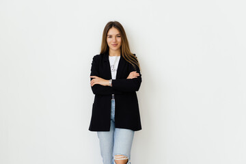 Portrait of beautiful young businesswoman smiling, standing with arms crossed over white background