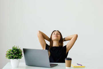 Business woman relaxing with her hands behind her head and sitting on a chair in office