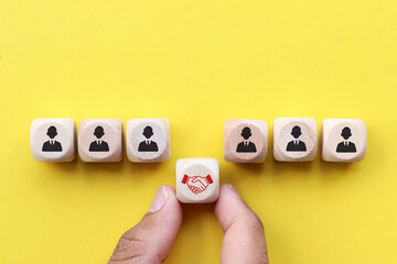 wooden block with people icon on yellow background, teamwork concept