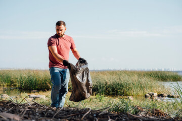 Male activist searching garbage during sunny day