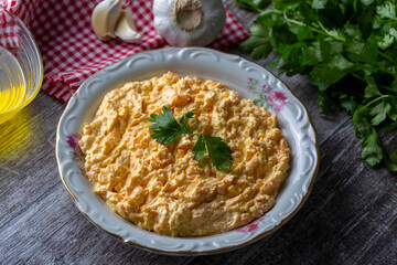 Traditional delicious Turkish foods; Fresh carrot salad with garlic yogurt in bowl. ( Turkish name; havuc tarator) Carrot tarator in ceramic bowl with vegetable on dark background.