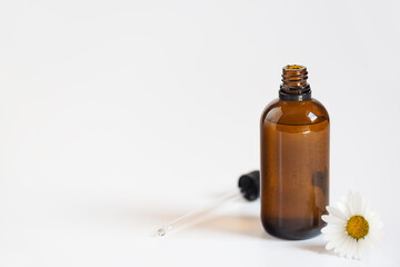 Cosmetic oil with chamomile glass bottle. Horizontal orientation, copy space.