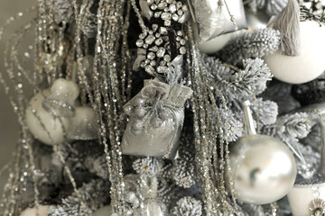 Close up of holidays location with toys and garlands on white and gray Christmas tree