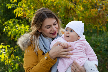 Happy beautiful mother spending time with her little baby girl in nature.