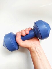 blue dumbbell in hand on a white background, the concept of sports